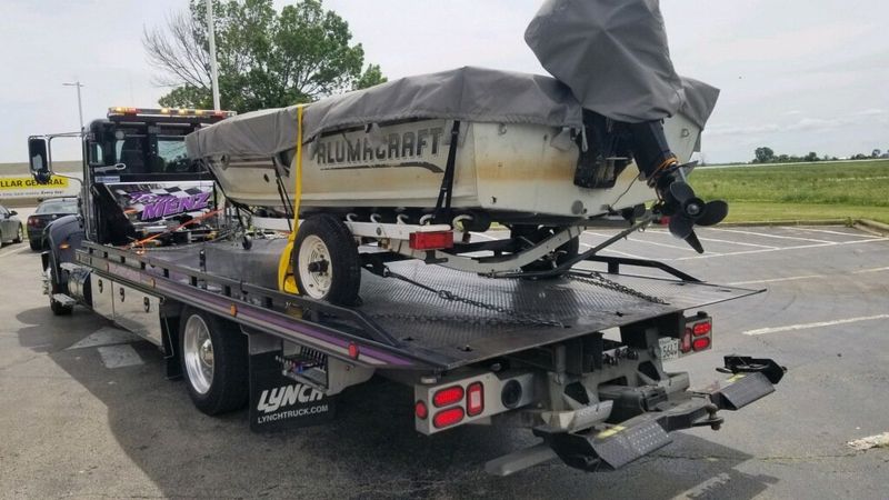 Larry Menz flatbed carrying an Alumacraft boat on a trailer